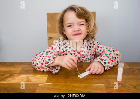 Cute blonde Mädchen Selbsttest für Corona-Virus und warten auf Ergebnisse. Stockfoto