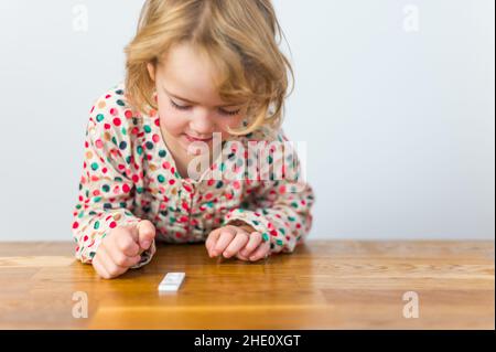 Cute blonde Mädchen Selbsttest für Corona-Virus und warten auf Ergebnisse. Stockfoto