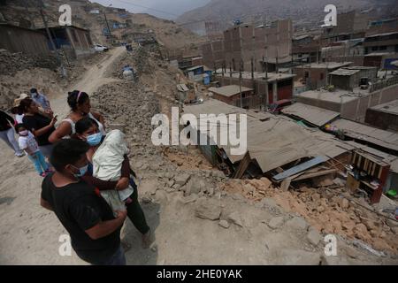 San Juan De Lurigancho, Peru. 07th Januar 2022. Bewohner stehen neben dem Schaden in einem Vorort der Hauptstadt nach einem Erdbeben der Stärke 5,6. Das Zentrum des Bebens befand sich in einer Tiefe von 109,7 Kilometern und wurde am Morgen gefühlt. Kredit: Gian Masko/dpa/Alamy Live Nachrichten Stockfoto