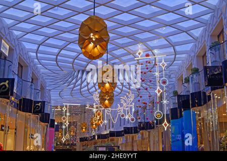 Großbritannien, West Yorkshire, Leeds, Victoria Gate Shopping Centre Weihnachtsdekorationen und bunte Decke Stockfoto