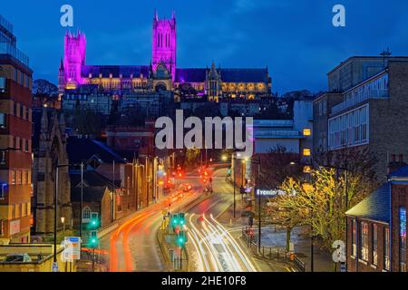 UK, Lincolnshire, Lincoln Cathedral Western und Central Towers und Südfassade mit Adventsbeleuchtungen, die von einer Fußgängerbrücke über die Melville Street aus gesehen werden Stockfoto