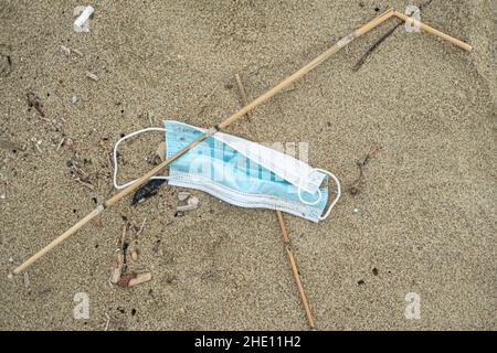 Gebrauchte chirurgische Gesichtsmaske, die auf dem Meeresküsten-Ökosystem weggeworfen wurde, covid19 Abfälle der Pandemie-Seuche Stockfoto