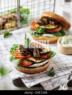 Gesunde vegane Burger mit gegrilltem Gemüse und Sauce Stockfoto