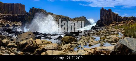 Panorama von Wellen, die über Basaltgesteinsformationen im Bombo Headland Steinbruch, Küste von New South Wales, Australien, brechen Stockfoto