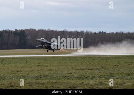 Der US F-16 Fighting Falcon, der dem Kampfgeschwader 480th zugewiesen wurde, hebt ab, um ein Training durchzuführen und Sortie abzufangen, während er am 6. Januar 2022 die Qualifikation der NATO zur verstärkten Luftpolizik auf dem Luftwaffenstützpunkt Łask, Polen, absolviert. Die Fähigkeit, agile Kampfanstellung durch verbesserte Luftreinhaltungs-Maßnahmen für verschiedene Zeiträume durchzuführen, ermöglicht es uns, die flexible und skalierbare Reaktion zu demonstrieren, die die verbesserte Luftreinhaltungs-Funktion in einer sich entwickelnden Sicherheitssituation bietet. (USA Luftwaffe Foto von Senior Airman Ali Stewart) Stockfoto