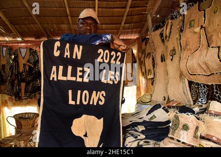 (220108) -- YAOUNDE, 8. Januar 2022 (Xinhua) -- das Foto vom 21. Dezember 2021 zeigt einen lokalen Modedesigner in seinem Laden, der traditionelle Kleidung für den Africa Cup of Nations (AFCON) in Yaounde, der Hauptstadt von Kamerun, zeigt. Afrika Cup of Nations (AFCON) des Fußballs, ein alle zwei Jahre stattfindende Wettbewerb wird an diesem Sonntag in Yaounde, der Hauptstadt von Kamerun, starten. Als wichtiges Sportereignis auf dem Kontinent hat es die Aufmerksamkeit aller kamerunischen Fans auf sich gezogen. Als Auftakt zur Eröffnungsfeier konnte bereits in der Stadt eine Atmosphäre dieses Wettbewerbs bemerkt werden. (Foto von Kepdeu/Xinhua) Stockfoto