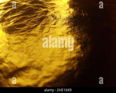 Golden glänzende Folie Blatt Nahaufnahme Hintergrund. Stockfoto