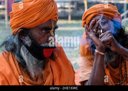 Kalkutta, Indien. 07th Januar 2022. Ein Sadhu sah das Rauchen im Gangasagar Durchgangslager. Gangasagar mela-Vorbereitungen wurden aufgrund einer Petition zur Beendigung der diesjährigen Pilgermesse aufgrund der COVID-19/Omicron-Zahlen in Westbengalen und im ganzen Land ausgesetzt. Der hohe Gerichtshof von Kalkutta gab Gangasagar Mela mit gewissen Einschränkungen grünes Licht. Kredit: SOPA Images Limited/Alamy Live Nachrichten Stockfoto