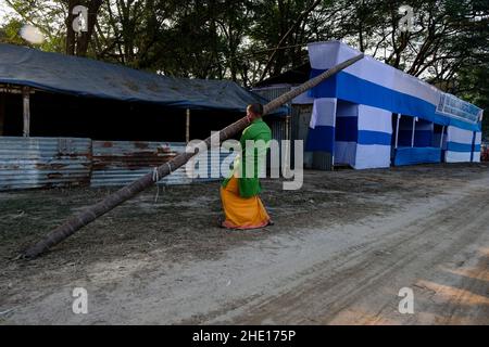 Kalkutta, Indien. 07th Januar 2022. Ein Pilger trägt einen Kofferraum für die Herstellung des provisorischen Zeltes im Gangasagar-Durchgangslager. Gangasagar mela-Vorbereitungen wurden aufgrund einer Petition zur Beendigung der diesjährigen Pilgermesse aufgrund der COVID-19/Omicron-Zahlen in Westbengalen und im ganzen Land ausgesetzt. Der hohe Gerichtshof von Kalkutta gab Gangasagar Mela mit gewissen Einschränkungen grünes Licht. (Foto von Dipayan Bose/SOPA Images/Sipa USA) Quelle: SIPA USA/Alamy Live News Stockfoto