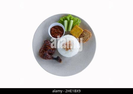 Pecel Ayam oder Ayam Penyet ist ein traditionelles indonesisches gebratenes Huhn mit frischem Gemüse, Chilisauce oder Sambal, Tofu und Tempeh Stockfoto