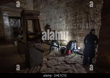 Restauratoren arbeiten an der Reparatur und Wiederherstellung der alten ägyptischen Steinmauern mit Hieroglyphen und Reliefskulptur an einem historischen Ort bedeckt. Stockfoto