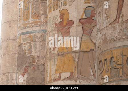 Alte ägyptische Reliefskulpturen, die gut erhalten geblieben sind und auf die Säulen in der Hypostyle-Halle in Karnak, Ägypten, gemalt wurden. Stockfoto