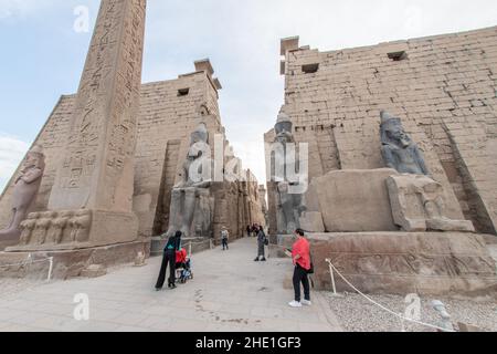 Der Eingang zum Luxor-Tempel, flankiert von sitzenden Statuen von König Ramses II., in Ägypten. Stockfoto