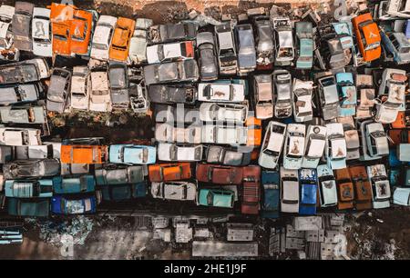 Luftaufnahme einer sowjetischen Autodumpe von einer Drohne. Schießen von oben auf Haufen rostiger Autos. Verlassene russische Autos warten auf Entsorgung und Stockfoto