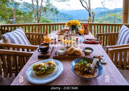 Blick von oben auf ein luxuriöses Frühstück in den Bergen von Chiang Mai Thailand, Luxus-Frühstück mit Chiang Mai-Nudelsuppe oder Khao Soi Gai und Obst und Kaffee auf dem Tisch Stockfoto