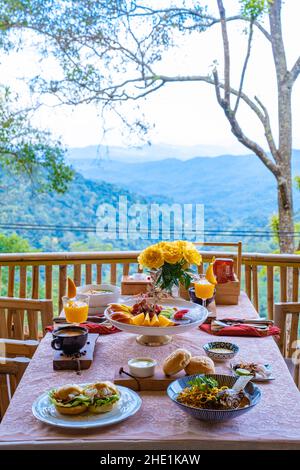 Blick von oben auf ein luxuriöses Frühstück in den Bergen von Chiang Mai Thailand, Luxus-Frühstück mit Chiang Mai-Nudelsuppe oder Khao Soi Gai und Obst und Kaffee auf dem Tisch Stockfoto