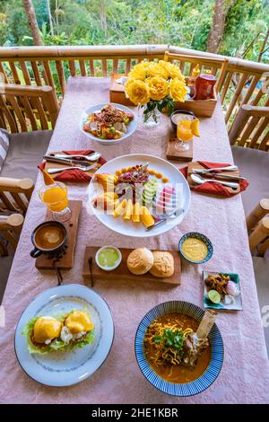 Blick von oben auf ein luxuriöses Frühstück in den Bergen von Chiang Mai Thailand, Luxus-Frühstück mit Chiang Mai-Nudelsuppe oder Khao Soi Gai und Obst und Kaffee auf dem Tisch Stockfoto