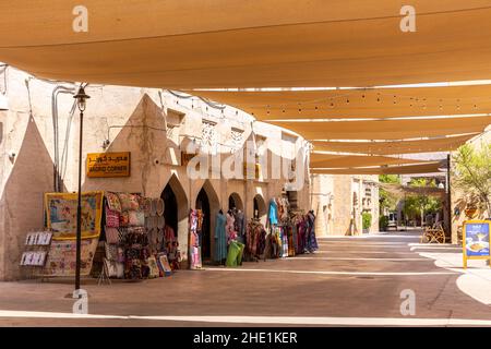 Dubai, VAE, 27.09.2021. Al Fahidi Historical District Steinstraße mit traditionellen Kunsthandwerk Souvenirläden und Sonnenschirmen oben, Deira, Dubai. Stockfoto