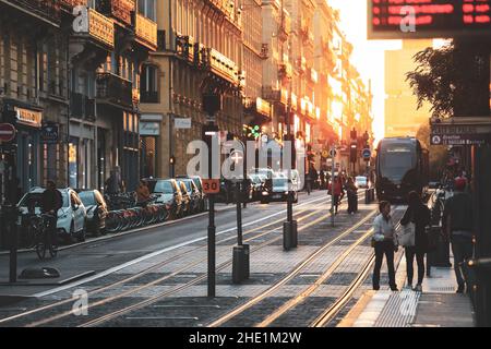 Bordeaux, France- 2 November, 2019 : selektiver Fokus auf Straßenbelag, Straßenszene in der Stadt, Menschen, die während des Sonnenuntergangs in Bordea mit der Straßenbahn auf der Straße spazieren Stockfoto