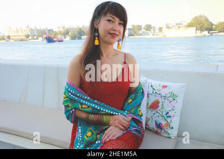 Hübsche Thailänderin sitzt am Ufer des Flusses, gesundes Lebenskonzept Stockfoto