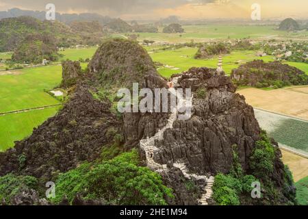 Kalksteinfelsen und Bergpagode vom Hang Mua Temple Aussichtspunkt an einem regnerischen Tag. Ninh Binh, Vietnam Stockfoto