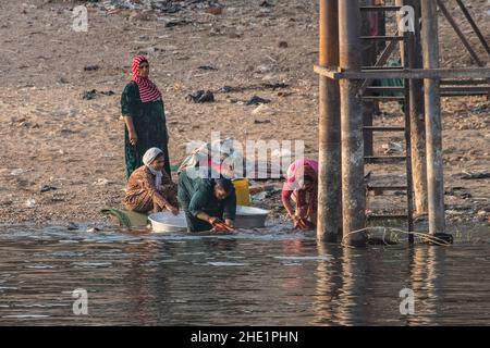 Ägyptische Frauen waschen ihre Kleidung und waschen ihre Wäsche im Nil. Stockfoto