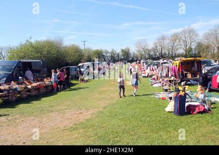 Pennant Auto Boot Verkauf, zeigt Stände von Autos und Menschen, die herumlaufen und sich Artikel zum Verkauf angucken. Blauer Himmel und grünes Gras gesäumt von Bäumen Stockfoto