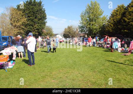 Pennant Auto Boot Verkauf, zeigt Stände von Autos und Menschen, die herumlaufen und sich Artikel zum Verkauf angucken. Blauer Himmel und grünes Gras gesäumt von Bäumen Stockfoto