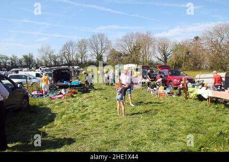 Pennant Auto Boot Verkauf, zeigt Stände von Autos und Menschen, die herumlaufen und sich Artikel zum Verkauf angucken. Blauer Himmel und grünes Gras gesäumt von Bäumen Stockfoto