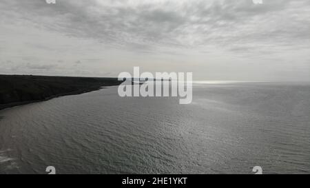 Luftbild mit Blick auf die Küste von Llanon, das Meer, den Küstenweg, Felder und den Strand zeigt Stockfoto