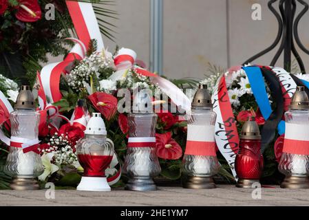 Rote und weiße Kerzen und Blumen in den Farben der polnischen Flagge, nationales Jubiläum in Polen. Polnische Nationalfarben. Stockfoto