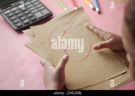 Handgehaltenes Papier mit handgezeichneter Note mit Plus im Kreis Stockfoto