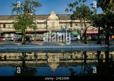 Malerische alte Lagerhäuser und Geschäfte säumen die Atsadang Road entlang des Klong (Kanal) Lod im historischen Stadtgebiet von Bangkok, Thailand, die sich im Wasser spiegeln Stockfoto