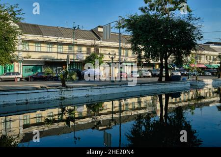 Malerische alte Lagerhäuser und Geschäfte säumen die Atsadang Road entlang des Klong (Kanal) Lod im historischen Stadtgebiet von Bangkok, Thailand, die sich im Wasser spiegeln Stockfoto