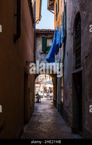 Kleine mittelalterliche Gasse im Seeufer der Stadt, Wäschestaukerei vor einem Fenster. Stockfoto