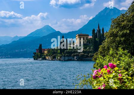 Eine wunderschöne Villa am See mit Gärten und Zypressen, die von der Villa Monastero über den Comer See gesehen wird. Stockfoto