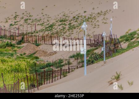 Zaun- und Überwachungskameras um die Singende Sanddüne in der Nähe von Dunhuang, Provinz Gansu, China Stockfoto