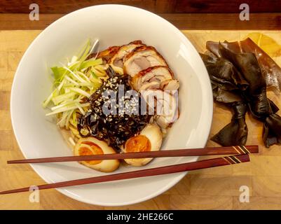 Japanische Ramen-Nudelsuppe mit marinierten Eiern, gekochtem Seetang, Chashu-Schwein und Brühe Stockfoto