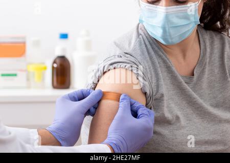 Aufnahme einer Ärztin, die einen Verband auf ihren Patientenarm anwendet Stockfoto