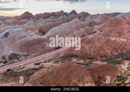 Straße durch Regenbogenberge des Zhangye Danxia National Geopark, Provinz Gansu, China Stockfoto