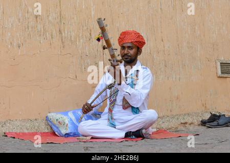 Ein einheimischer Mann in traditioneller Kleidung spielt eine Ravanahatha im Amber Fort (oder Amer Fort), Amer, in der Nähe von Jaipur, Rajasthan, Indien, Südasien. Stockfoto