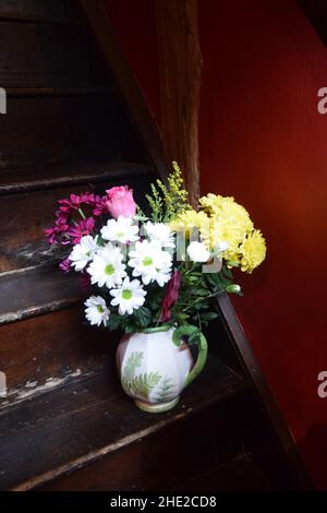 Krug mit gelben, weißen und rosa Blüten Stockfoto