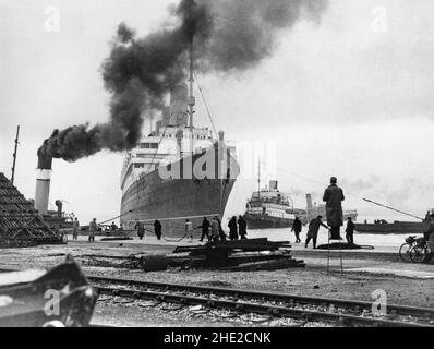 RMS Aquitania in Southampton Docks, England, Großbritannien Ende 1940s. Aquitania war ein britischer Ozeandampfer der Cunard Line. Sie wurde von John Brown & Company in Clydebank, Schottland, gebaut. Sie wurde 1913 gestartet und segelte am 30. Mai 1914 auf ihrer Jungfernfahrt von Liverpool nach New York. Im Ersten Weltkrieg wurde sie als Truppentransport und als Spitalschiff eingesetzt.während des Zweiten Weltkriegs diente sie als Truppentransport. Nach dem Krieg transportierte sie Migranten nach Kanada. Aquitania wurde 1949 aus dem Dienst zurückgezogen und im folgenden Jahr zum Verschrotten verkauft – ein Vintage-Foto aus dem Jahr 1940s. Stockfoto