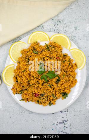 Bulgur-Salat (kisir) auf steinernem Hintergrund. Traditionelles, köstliches Essen. Vorspeisen der türkischen Küche. Draufsicht. Nahaufnahme Stockfoto