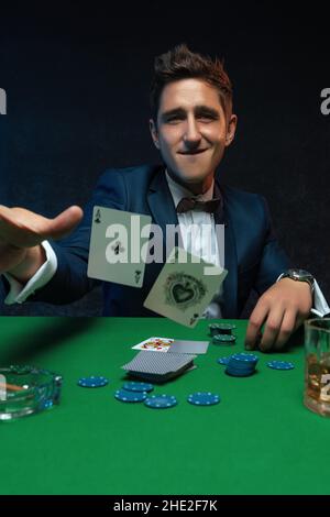 Pokerspieler wirft ein Paar Asse an den Tisch im Casino. Stockfoto