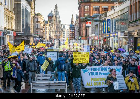 Während der „Freedom Rally“, einer Anti-Impfstoff-Demonstration, die von der Kampagnengruppe „Scotland Against Lockdown“ im Stadtzentrum von Glasgow organisiert wurde, marschieren Menschen die Argyle Street entlang. Bilddatum: Samstag, 8. Januar 2022. Stockfoto