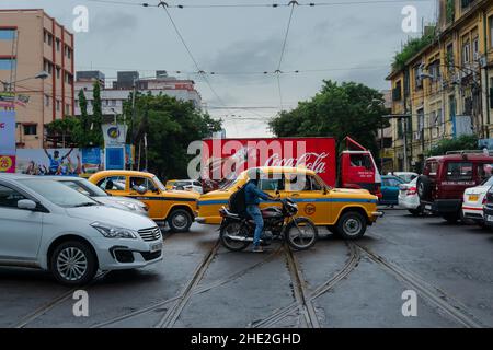 Kolkata, Westbengalen, Indien - 6th. August 2019 : Gelbes Taxi, Motorrad und Lieferwagen, viel Verkehr auf der Kolkata-Straße. Stockfoto