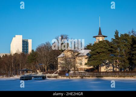 Kesäranta, die offizielle Residenz des Premierministers, mit dem Meilahti Tower Hospital im Hintergrund, an einem klaren Wintertag in Helsinki, Finnland Stockfoto