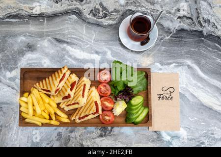 Toasten Sie auf einer hölzernen Servierplatte auf Marmorboden Stockfoto