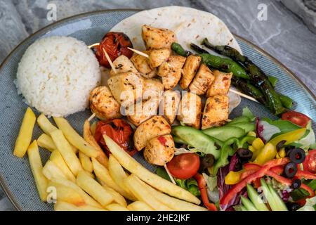 Gegrilltes Hähnchen auf einem Servierteller auf einem Marmorboden Stockfoto